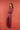 Woman wearing a maroon striped jumpsuit against a red background
