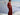 Person wearing a red outfit standing on a snowy mountain