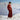Person wearing a red outfit standing on a snowy mountain