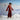 Woman in a red outfit standing in a snowy landscape with mountains in the background